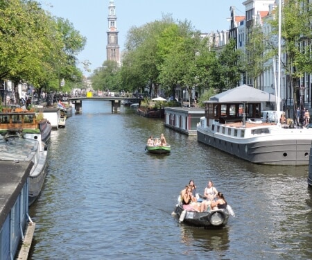 Due barche che navigano lungo i canali di Amsterdam.